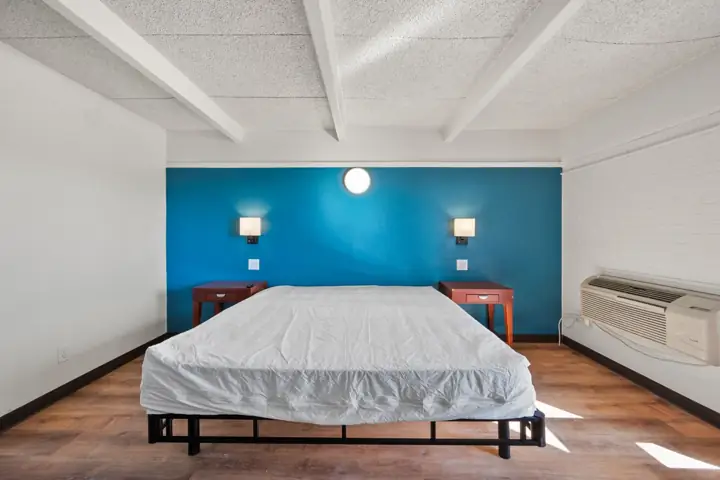 Bed and nightstands against a blue accent wall