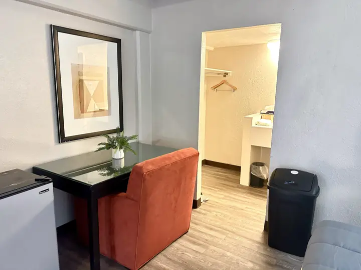 Desk, chair and mini refrigerator beside the closet