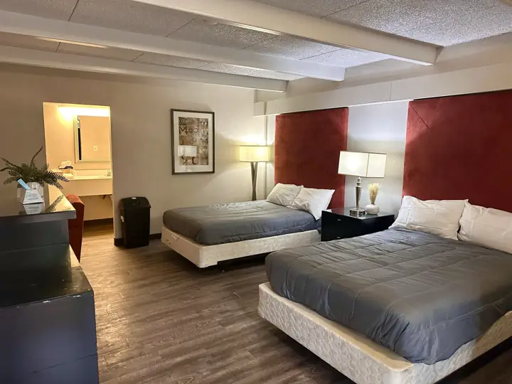 Room with two queen beds, red headboards and a vanity area