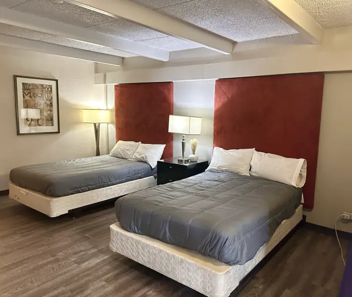 Two queen beds with gray bedding and framed artwork