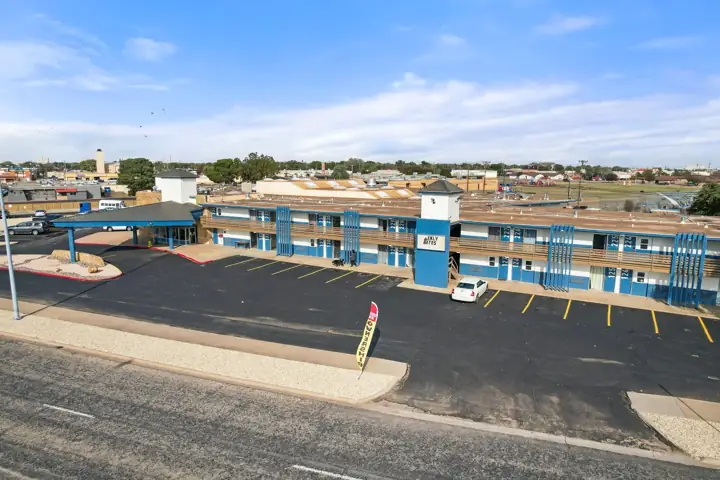 Two-story building with blue trim and guest parking